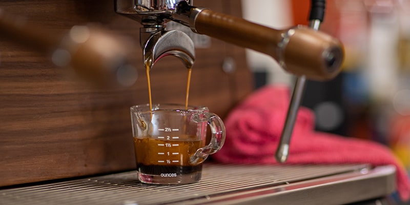 An espresso maker pouring a shot of espresso