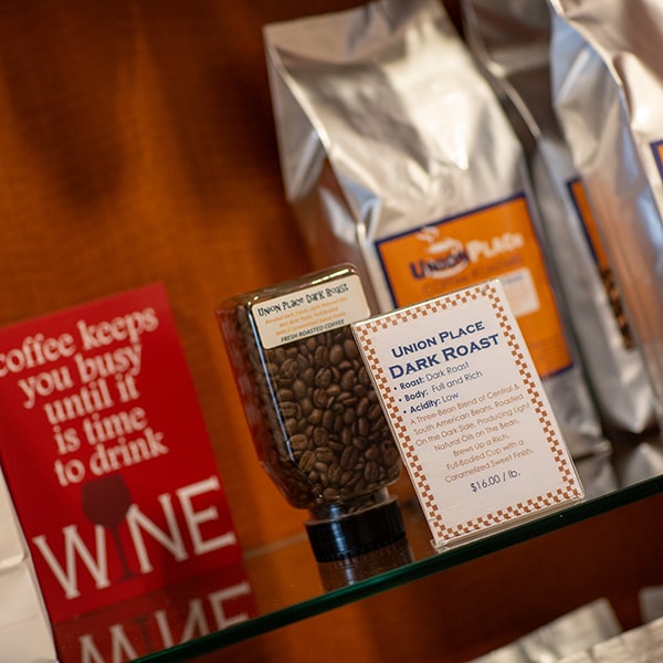 A shelf at Union Place Coffee Roasters with bags of dark roast coffee