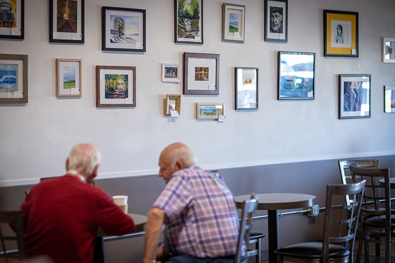 To gentlemen sitting at a table having a cup of coffee at Union Place Coffee Roasters